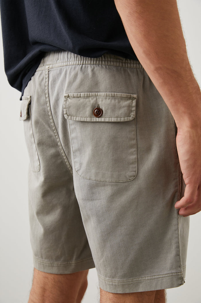 Cruz Shorts with a Drawstring Waist, Two Front Pockets, Two Back Button Flap Pockets in Washed Grey Colorway - Back View Featured on Model