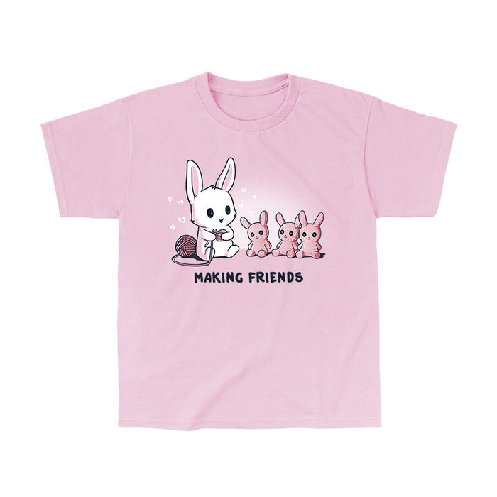 Classic Cotton T-shirt_Teeturtle light pink Making Friends apparel featuring a white bunny knitting 3 bunny friends out pink of yarn, caption reads, "Making Friends'.