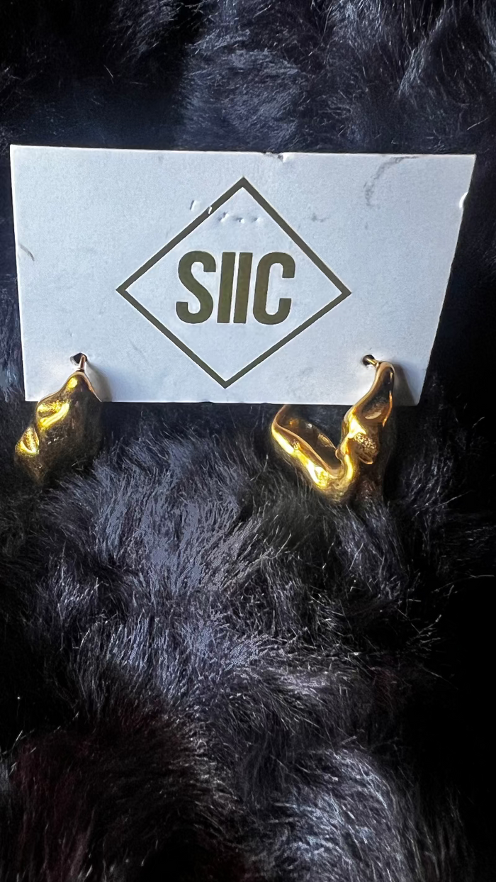 Gold devil horns with a white card displaying 'SIIC' on a dark background