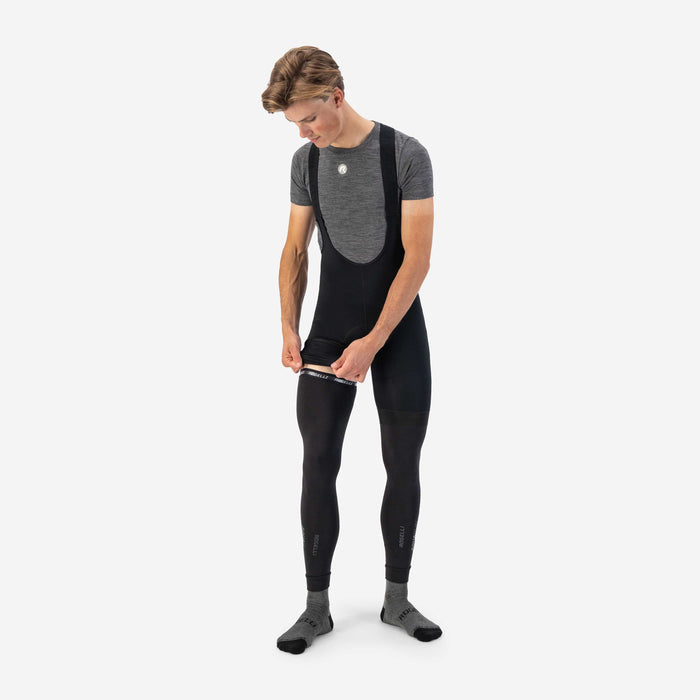 Rogelli Aquabloc armwarmers zwart als verlenging van korte fietsbroek aantrekken over linkerbeen.