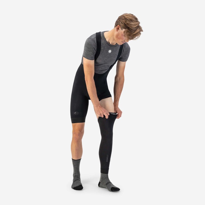 Rogelli Aquabloc armwarmers zwart als verlenging van korte fietsbroek aantrekken over rechterbeen.