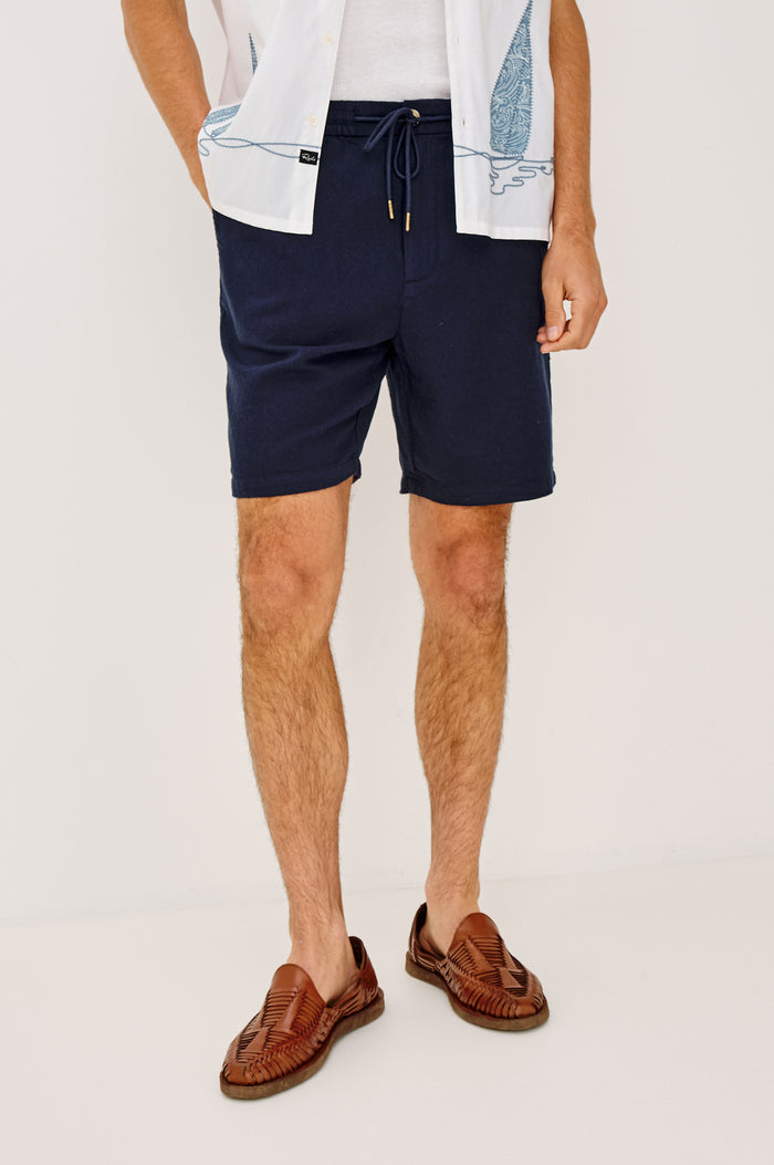 Archer Short in Cotton-Linen Blend With 8.5″ Inseam, Relaxed Fit, Elastic Drawstring Waist, Front Zip Fly, Side Pockets, and Back Welt Pocket in Deep Meridian Colorway - Lower Body Front View Featured on Model