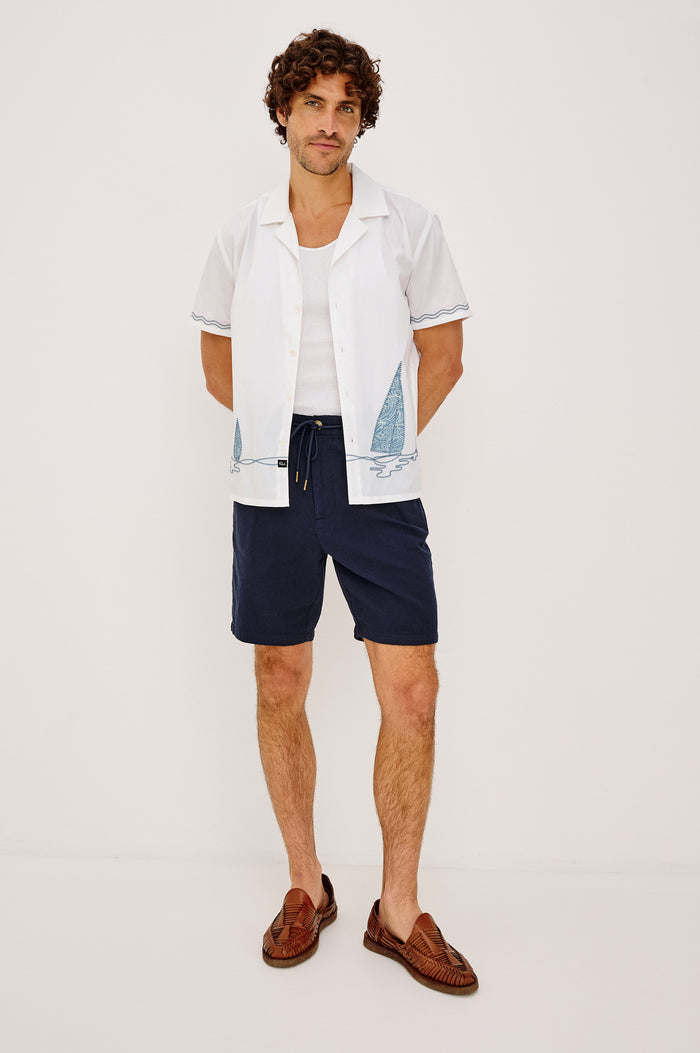 Archer Short in Cotton-Linen Blend With 8.5″ Inseam, Relaxed Fit, Elastic Drawstring Waist, Front Zip Fly, Side Pockets, and Back Welt Pocket in Deep Meridian Colorway - Full Body Front View Featured on Model