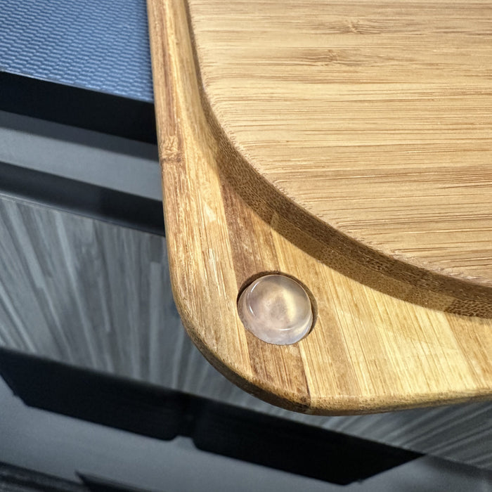 Close-up of a bamboo sink cover corner with non-slip bumper in a van kitchen.