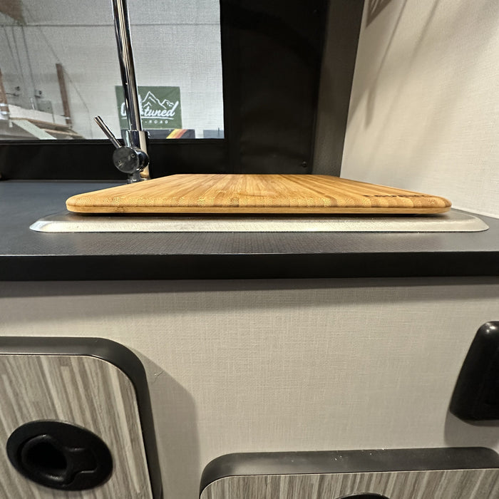 Bamboo sink cover fitted over a van sink in a Revel kitchen interior.