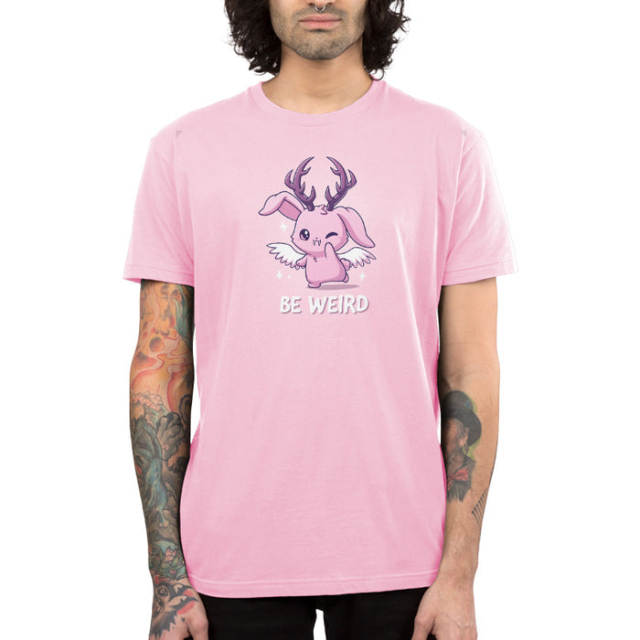 Premium Cotton T-shirt_TeeTurtle light pink Be Weird apparel featuring a winking wolpertinger. Caption says, "be weird".