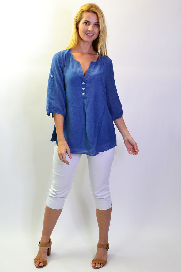 Blue Lagoon Stylius tunic top with flowing fabric and vibrant blue color, displayed on a hanger.