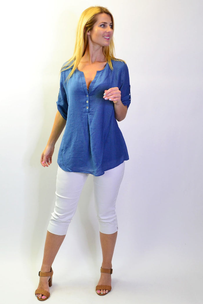 Blue Lagoon Stylius tunic top with flowing fabric and V-neck design, displayed on a hanger against a neutral background.