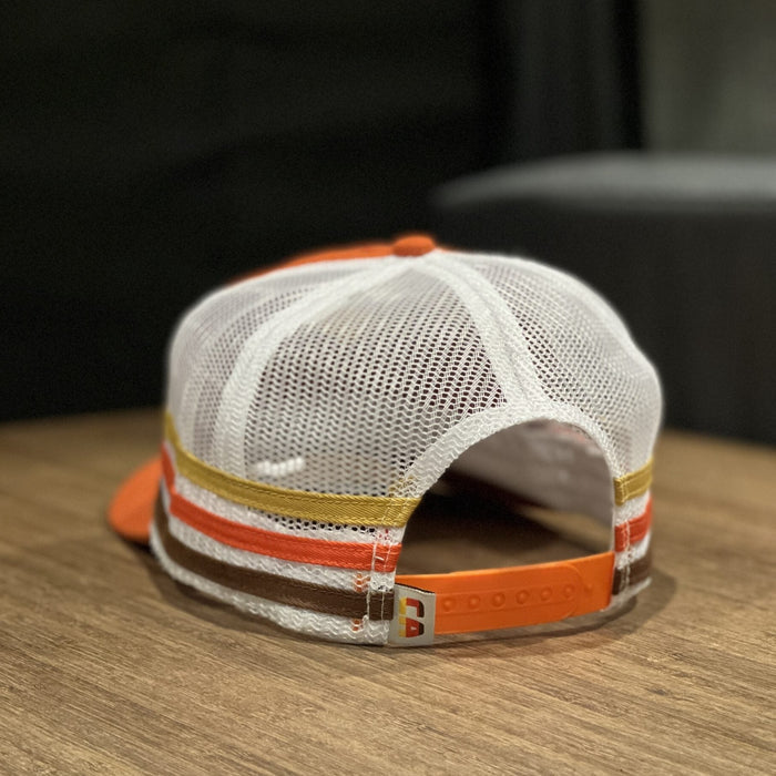 Back view of CA Trucker Hat with adjustable mesh strap and multicolor stripes on wood table