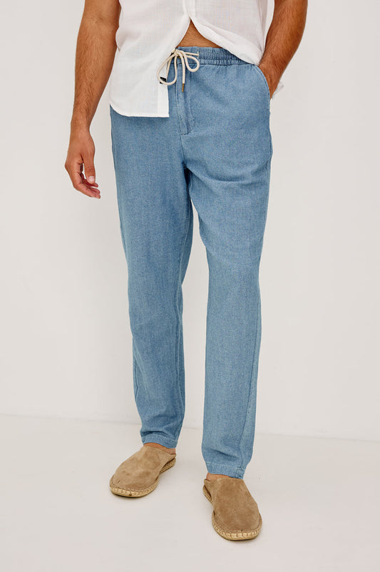 Callum Tapered Straight Leg Pant in Linen Twill With Adjustable Drawstring Waistband Ties in Medium Wash Indigo Colorway - Lower Body Front View Featured on Model