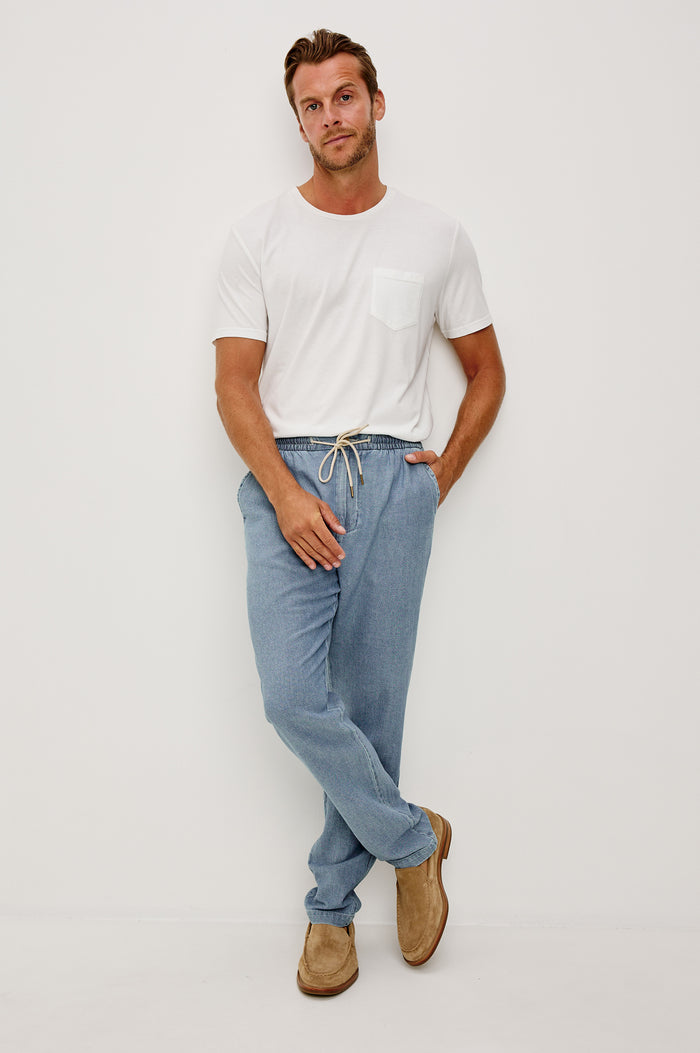 Callum Tapered Straight Leg Pant in Linen Twill With Adjustable Drawstring Waistband Ties in Medium Wash Indigo Colorway - Lower Body Back View Featured on Model