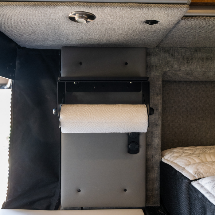 Canyon paper towel holder mounted inside a van near the bed and wall panel.