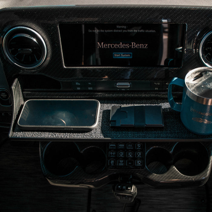 CAV D-ash Tray installed in a van dashboard holding a phone, wallet, and mug.