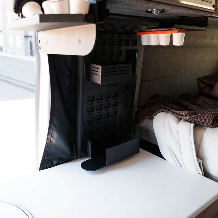 CAV MOLLE panel Keurig holder mounted inside van near bed and fold-down table.