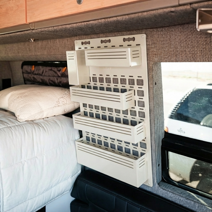 Storyteller Shower MOLLE Panel mounted on van wall above bed and next to window.