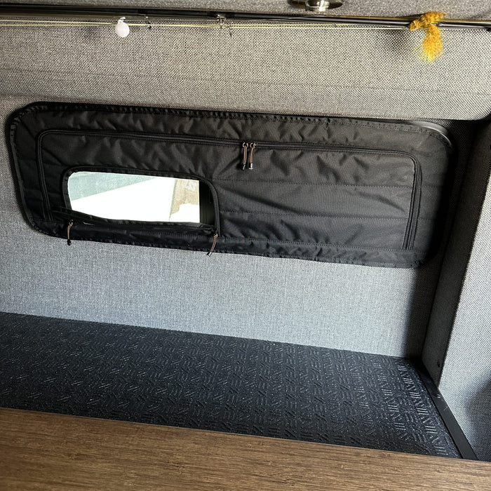 CLIMA-SHADE insulated bunk window cover installed inside a van with partially open zippered window flap.