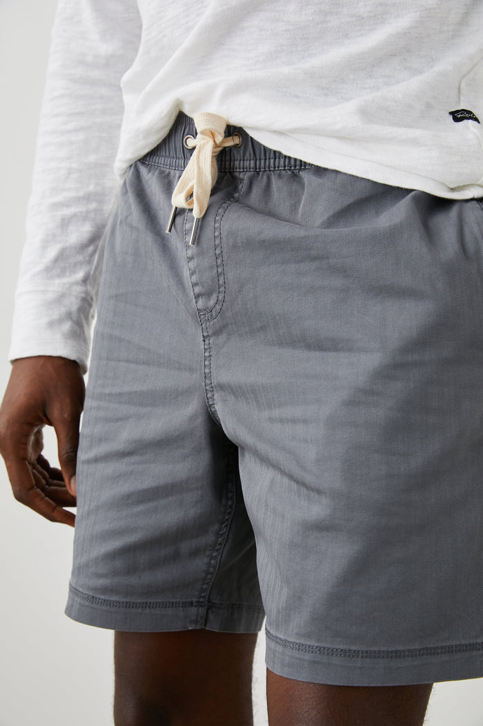 Cruz Shorts with a Drawstring Waist, Two Front Pockets, Two Back Button Flap Pockets in Charcoal Colorway - Front View Featured on Model