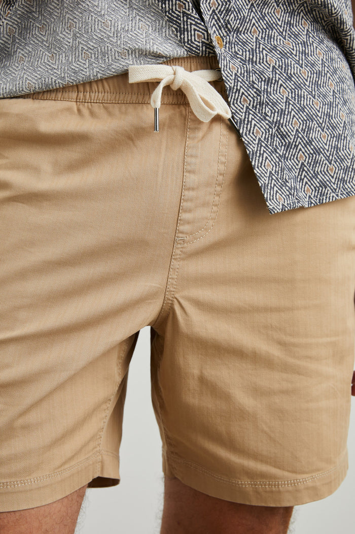 Cruz Shorts with a Drawstring Waist, Two Front Pockets, Two Back Button Flap Pockets in Khaki Colorway - Front View Featured on Model
