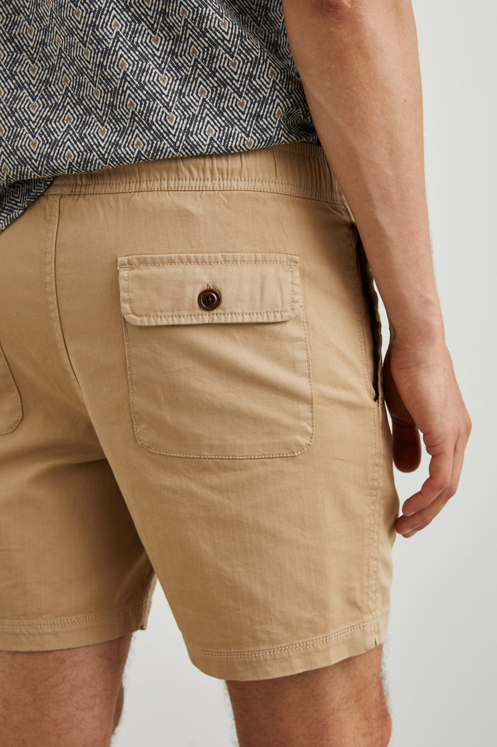 Cruz Shorts with a Drawstring Waist, Two Front Pockets, Two Back Button Flap Pockets in Khaki Colorway - Back View Featured on Model