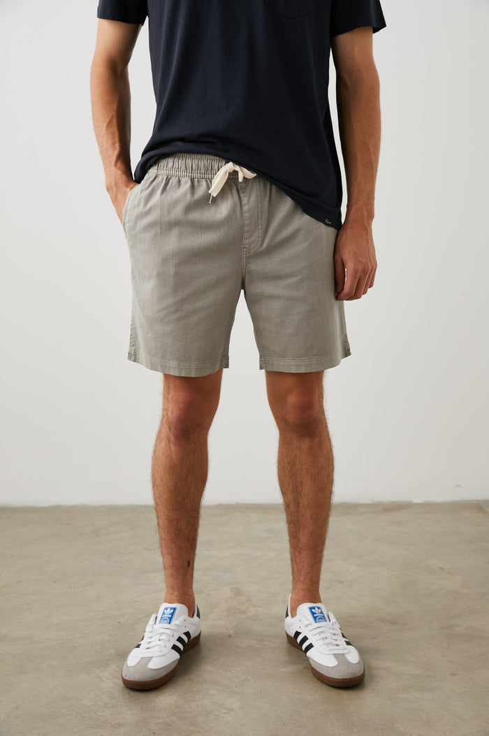 Cruz Shorts with a Drawstring Waist, Two Front Pockets, Two Back Button Flap Pockets in Washed Grey Colorway - Front View Featured on Model