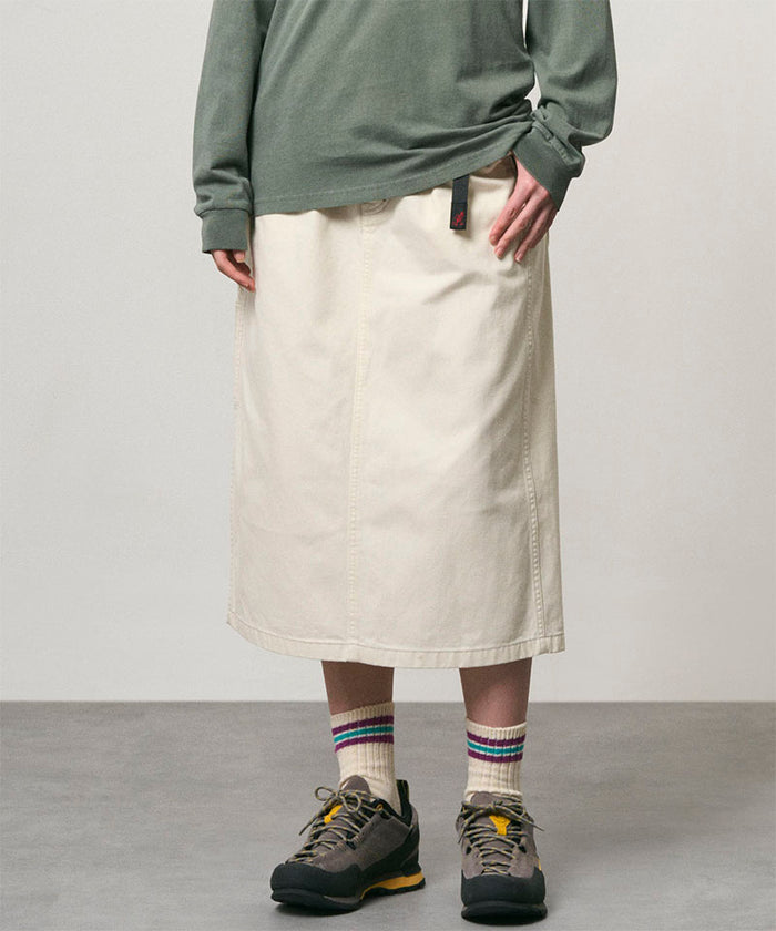 Model wearing a bone colored Gramicci Denim Carpenter Skirt and a olive shirt on a light-tone background.