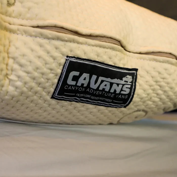 Close-up of CAVANS Ultra Luxe Series mattress cover showing textured fabric and stitched label.