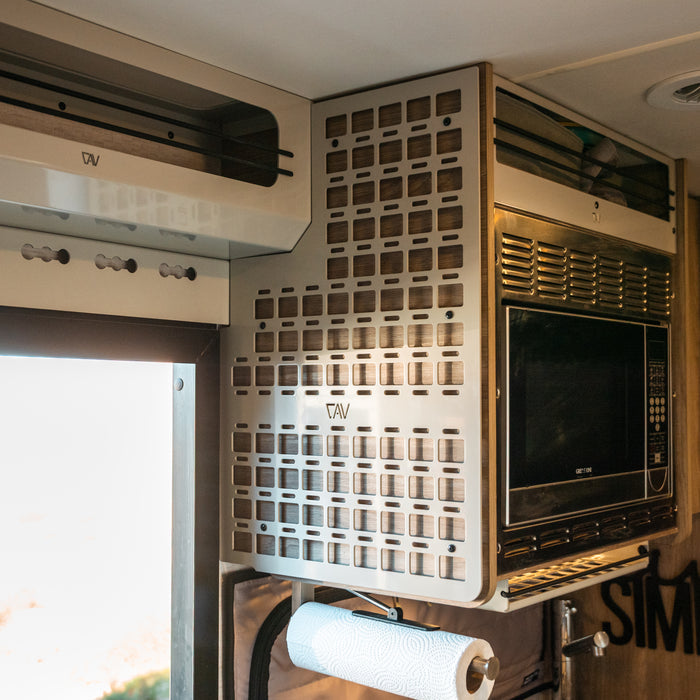 Ekko MOLLE panel mounted on the right side of a van interior beside a microwave unit.