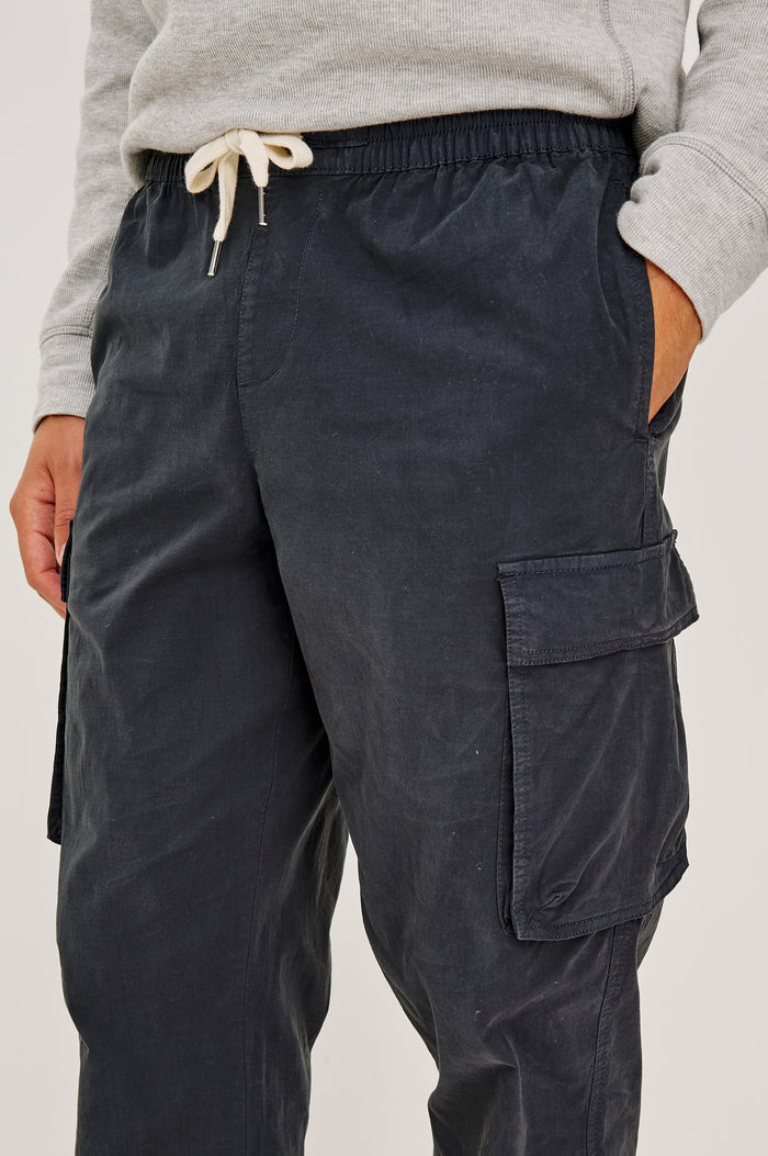 Emmerson Pant in Lightweight Cotton With Cargo Pockets and Drawstring Waist in Washed Black Colorway - Lower Body Front View Featured on Model
