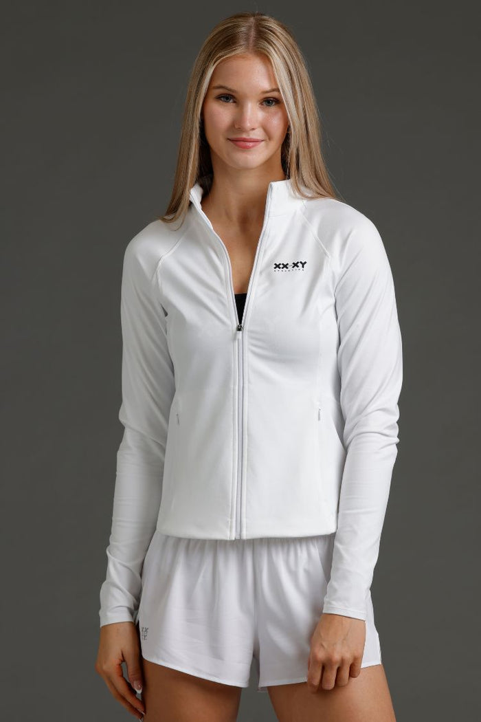Woman wearing a white athletic jacket and shorts with a brand logo || White