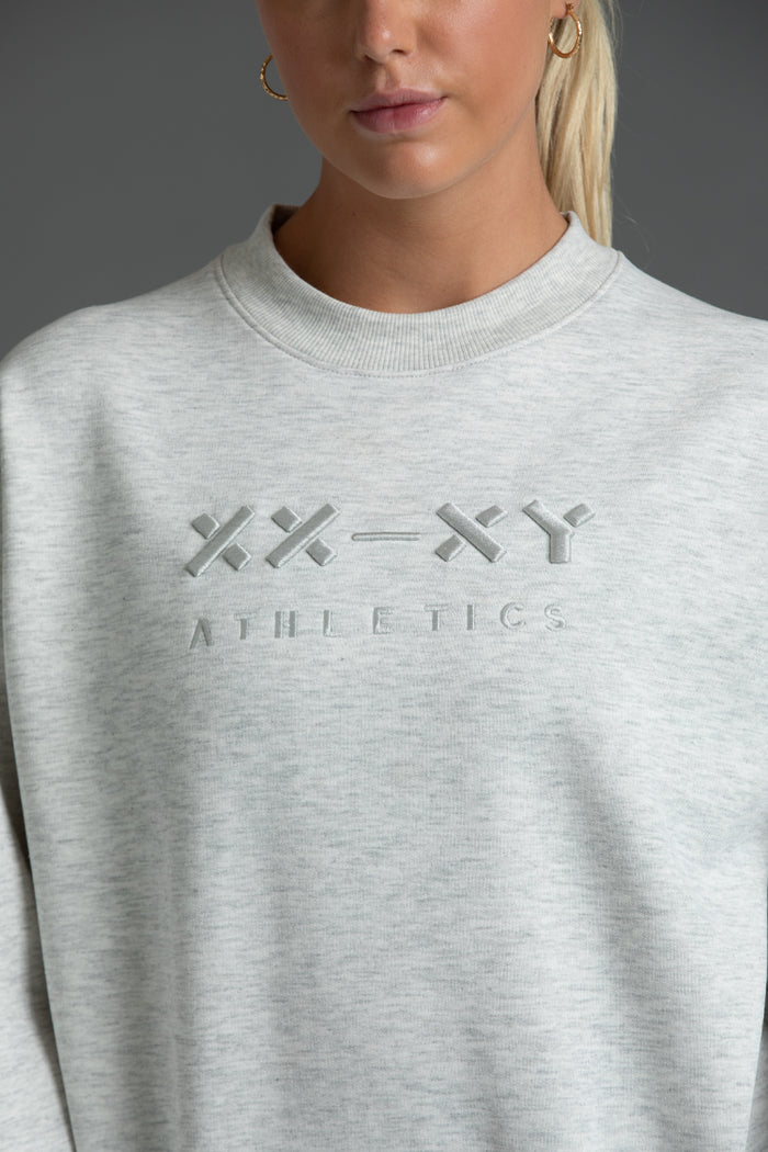 Gray sweatshirt with 'XY Athletics' logo worn by a person || Light Heather Gray