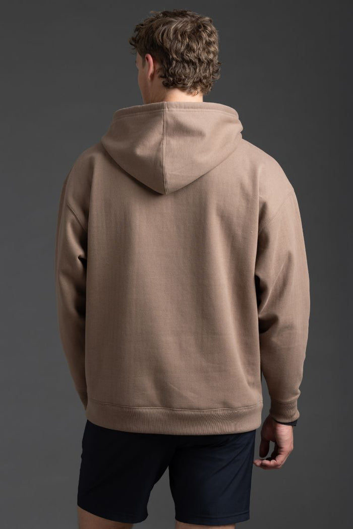 Person wearing a brown hoodie on a gray background || Mocha