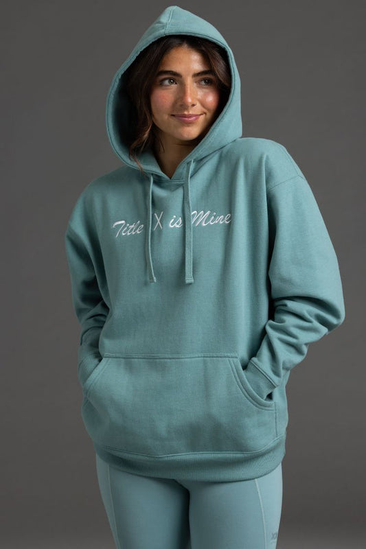 Person wearing a teal hoodie with 'Title X is Mine' text on a gray background || Underseas