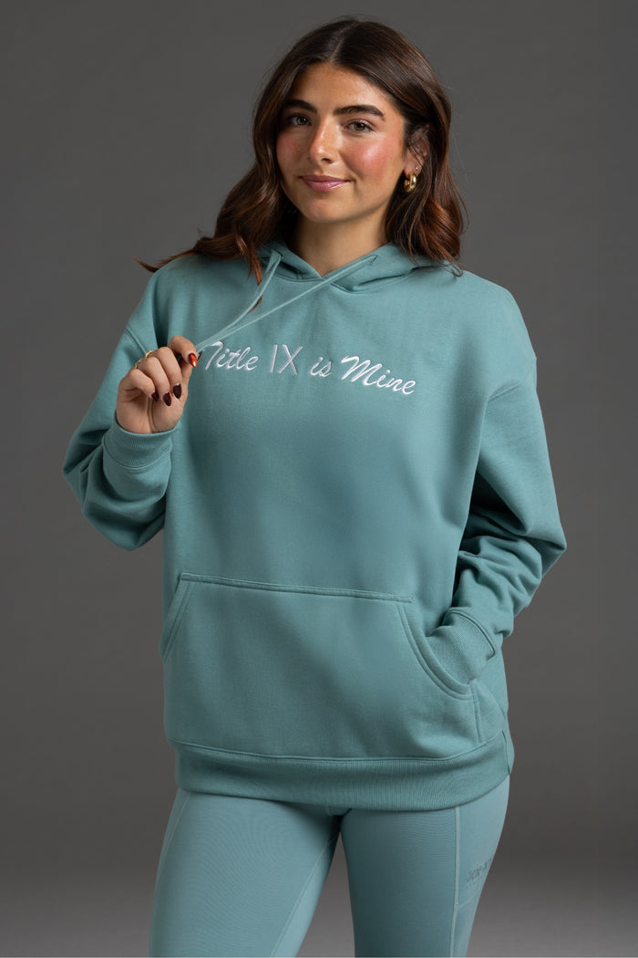 Person wearing a teal hoodie and leggings with text on a gray background || Underseas