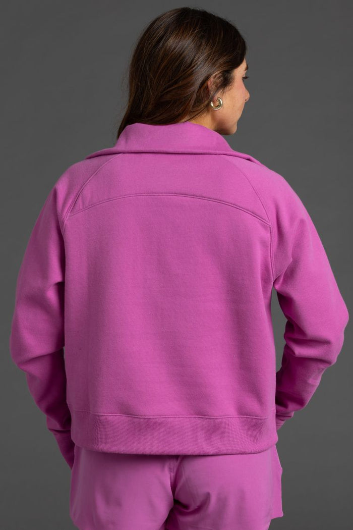 Person wearing a pink tracksuit against a gray background || Bright Fuchsia