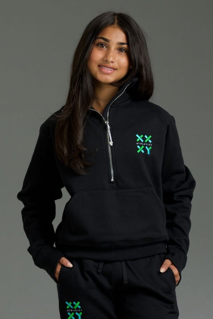 Person wearing a black hoodie with a logo on a gray background || Black