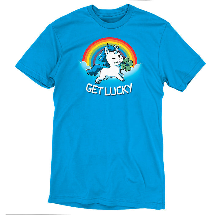 Premium Cotton T-shirt_Teeturtle cobalt blue Get Lucky apparel featuring a winking white unicorn holding a four-leaf clover while jumping through the clouds with a rainbow behind it. Caption reads, "get lucky".