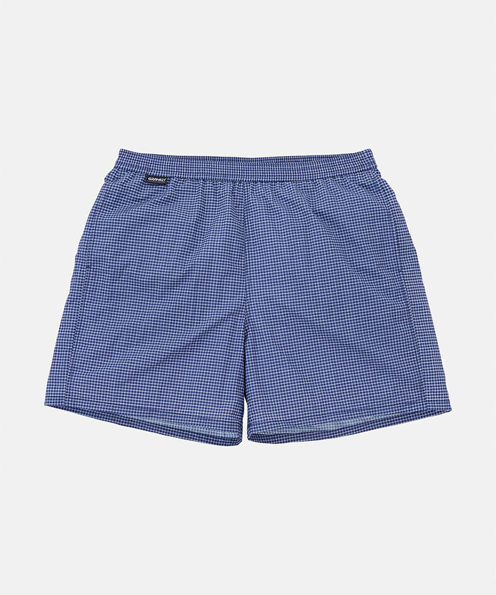 Front view of navy checkered Gramicci Grid Swim Shorts against a light-tone background.