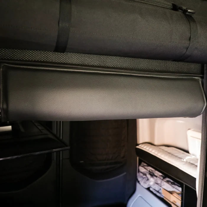 Padded head bumper installed on upper bed frame inside a 2019+ Revel van.