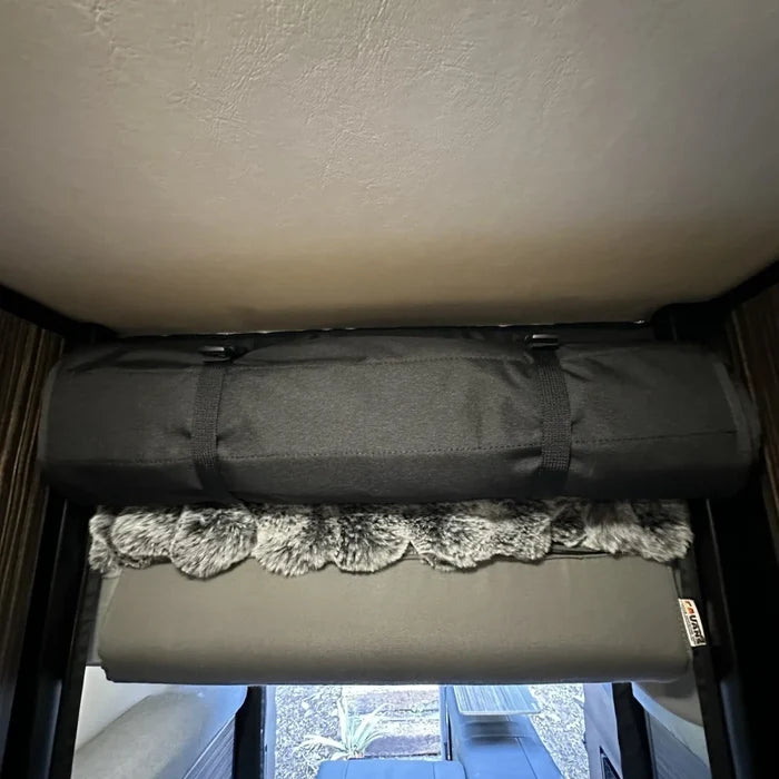 Black head bumper bed installed above rear door in a Revel van interior.