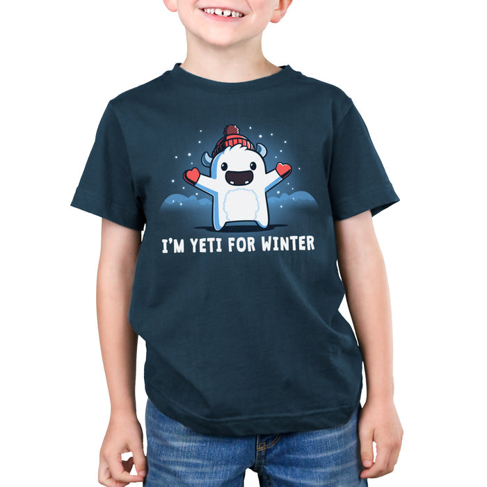 Premium Cotton T-shirt_Teeturtle denim blue I'm Yeti for Winter apparel featuring a happy Yeti in the snowy winter mountains wearing a pom-pom winter hat and mittens. Caption reads "I'm yeti for winter".