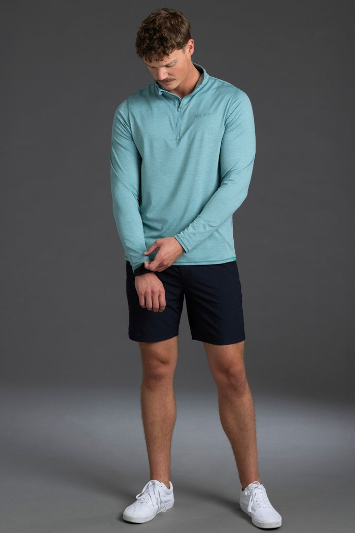 Man wearing a light blue pullover and black shorts on a gray background || Underseas