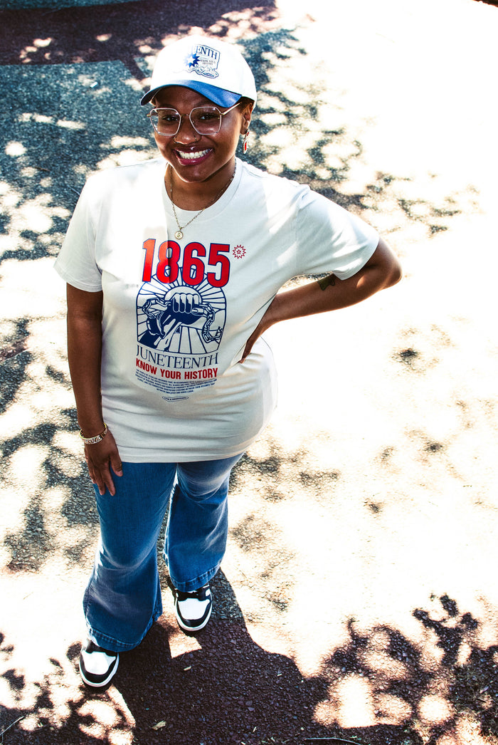 Model wearing the Juneteenth Know Your History tee with a matching Juneteenth snapback.