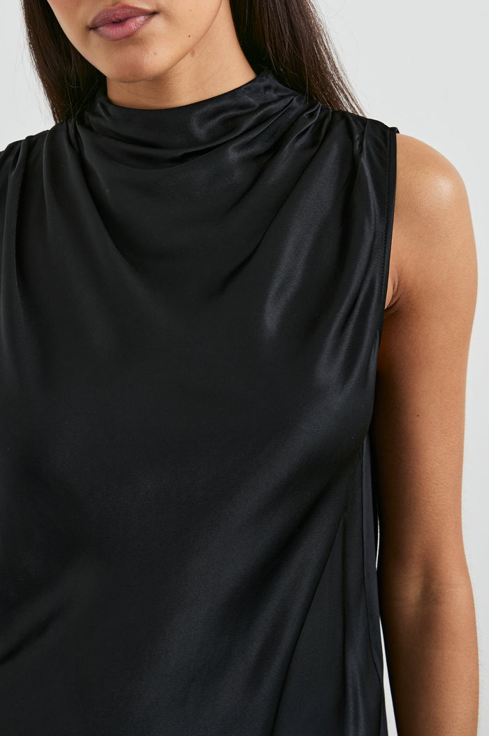 Kaleen Sleeveless Top with Mock Neck with Buttons and Keyhole on the Back and Draped Fabric on the Upper Chest in Ivory Colorway- Front View Featured on Model