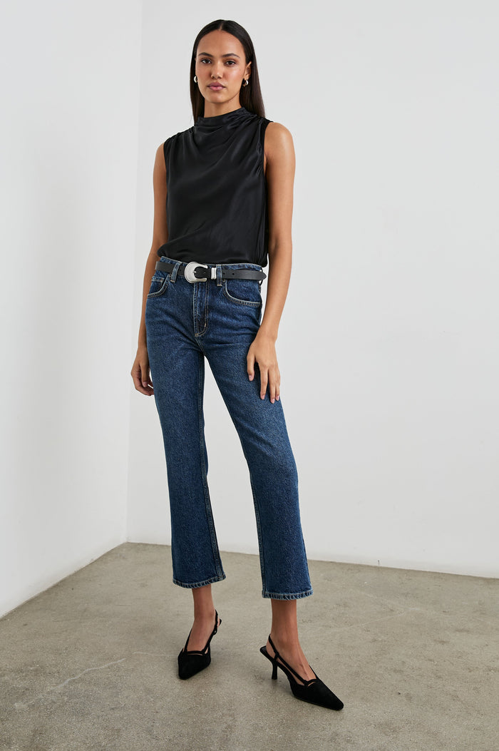 Kaleen Sleeveless Top with Mock Neck with Buttons and Keyhole on the Back and Draped Fabric on the Upper Chest in Ivory Colorway- Front Tucked Full Body View Featured on Model