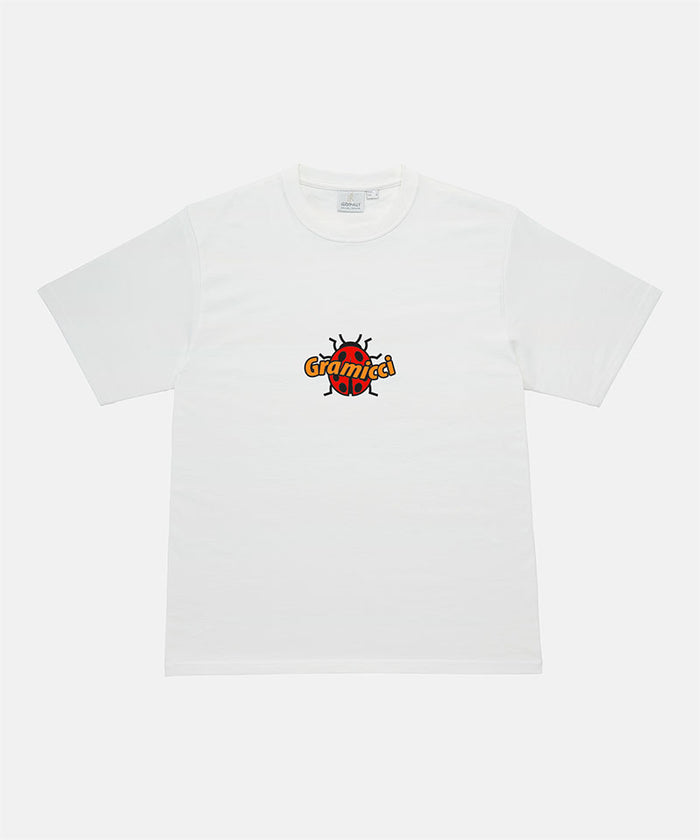 Gramicci white Ladybug Tee with colorful graphic against a light-tone background.