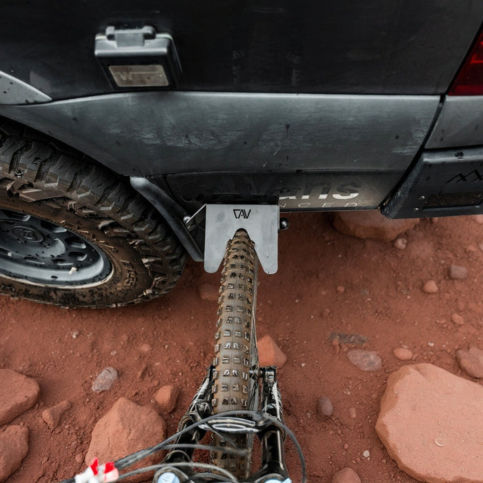 CAV Magnetic Bike Stand securing a mountain bike to the rear of a van on a rocky trail