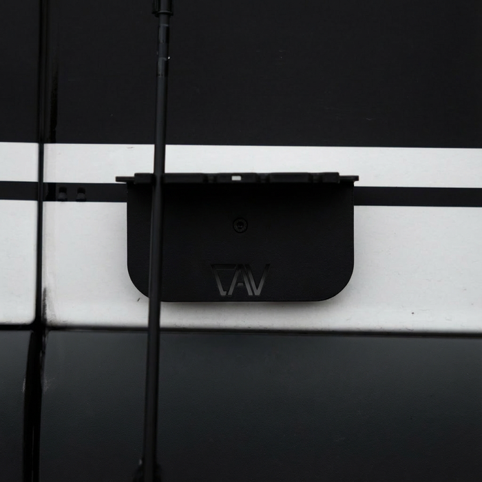 CAV magnetic fly rod holder mounted on the side of a van with fishing rods attached.