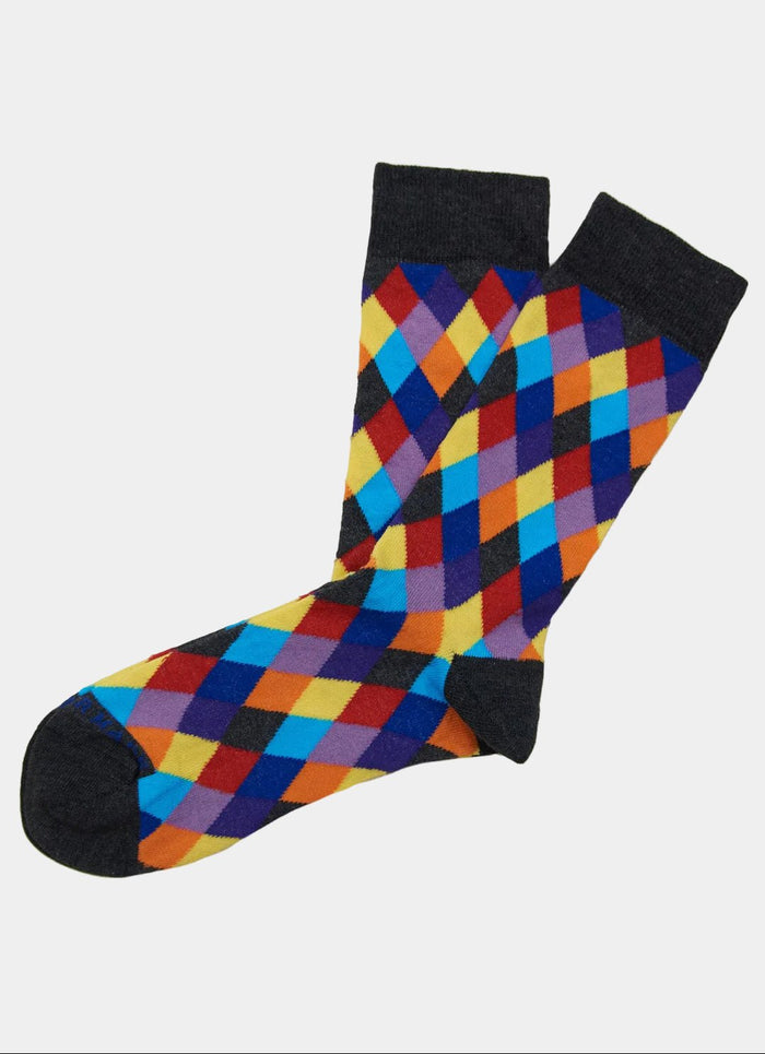 The Multi Harlequin Socks feature a vibrant argyle diamond pattern in yellow, blue, orange, purple, and red with dark grey toes, heels, and cuffs. Made in Turkey and available in sizes 8-12.