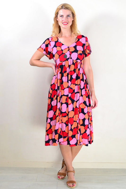 Pink orange spotted tunic dress by Hourglass, featuring a loose fit and vibrant pattern, displayed on a mannequin.