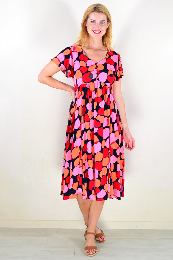 Pink orange spotted tunic dress by Hourglass, flowing fabric with colorful print and relaxed fit, perfect for casual wear.